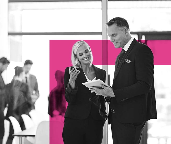 Two business people looking at an ipad in office