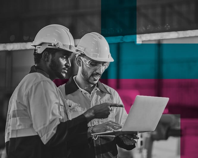 Two workers looking at laptop while working