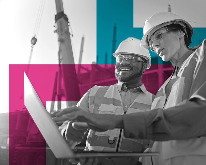 Two trades people looking at a laptop on construction site