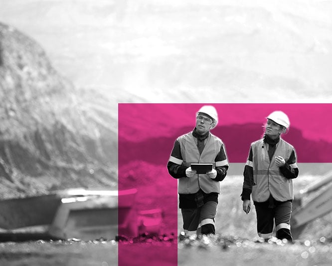 Two tradesmen walking through a mine site with ipad