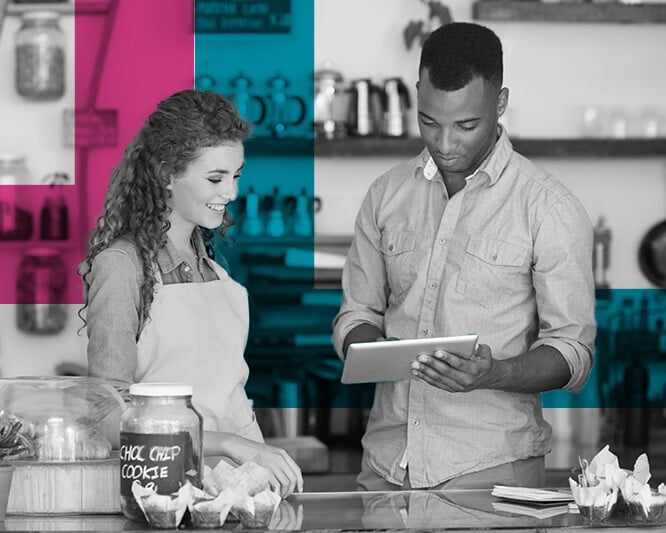 Two cafe workers reviewing ipad