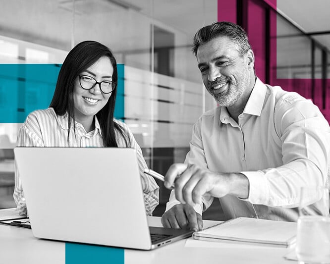 Man and woman smiling and looking at laptop