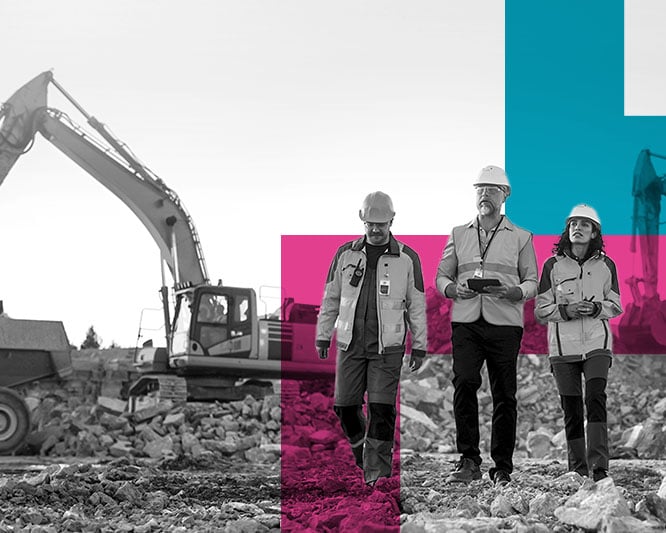 Three construction workers walking through a construction site with machines