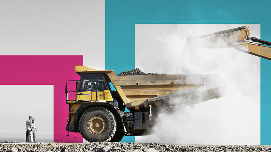 Two men looking at mining truck being loaded